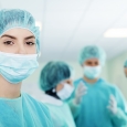 Young female surgeon with medical team in back before surgery